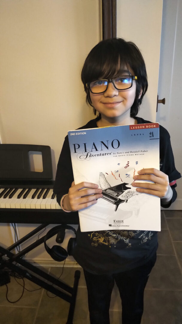 A girl holding up an electronic piano book.